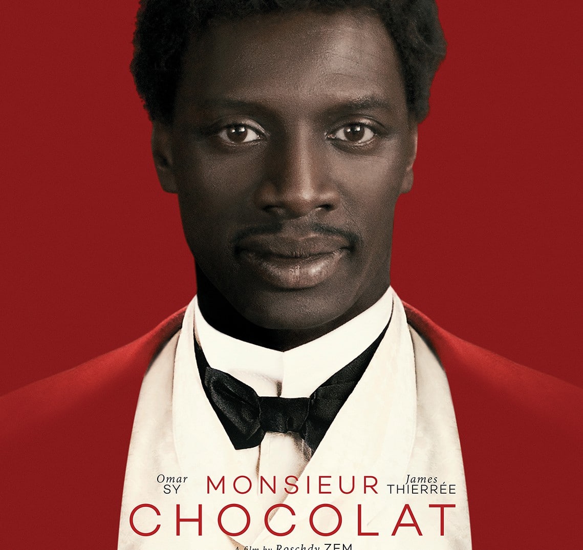 Filmaffiche van Monsieur Chocolat met Omar Sy in formele avondkleding tegen rode achtergrond