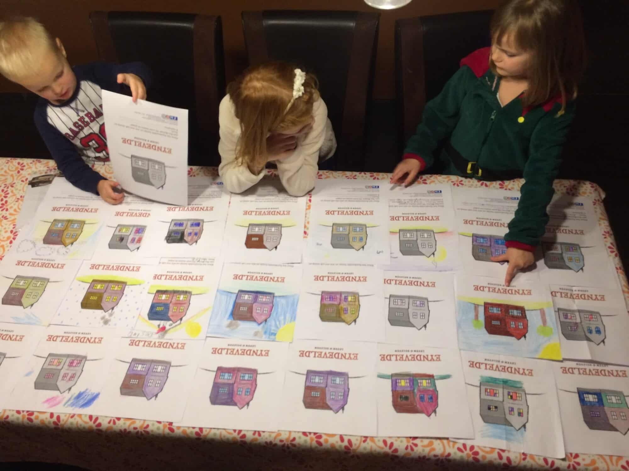 Kinderen aan tafel met kleurwedstrijd tekeningen van huisjes tijdens Herzele Popt Up evenement