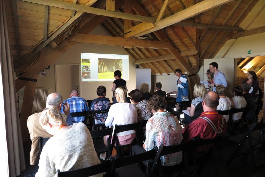 Logiesuitbaters tijdens presentatie nieuw logiesdecreet in houten vergaderzaal Eyndevelde