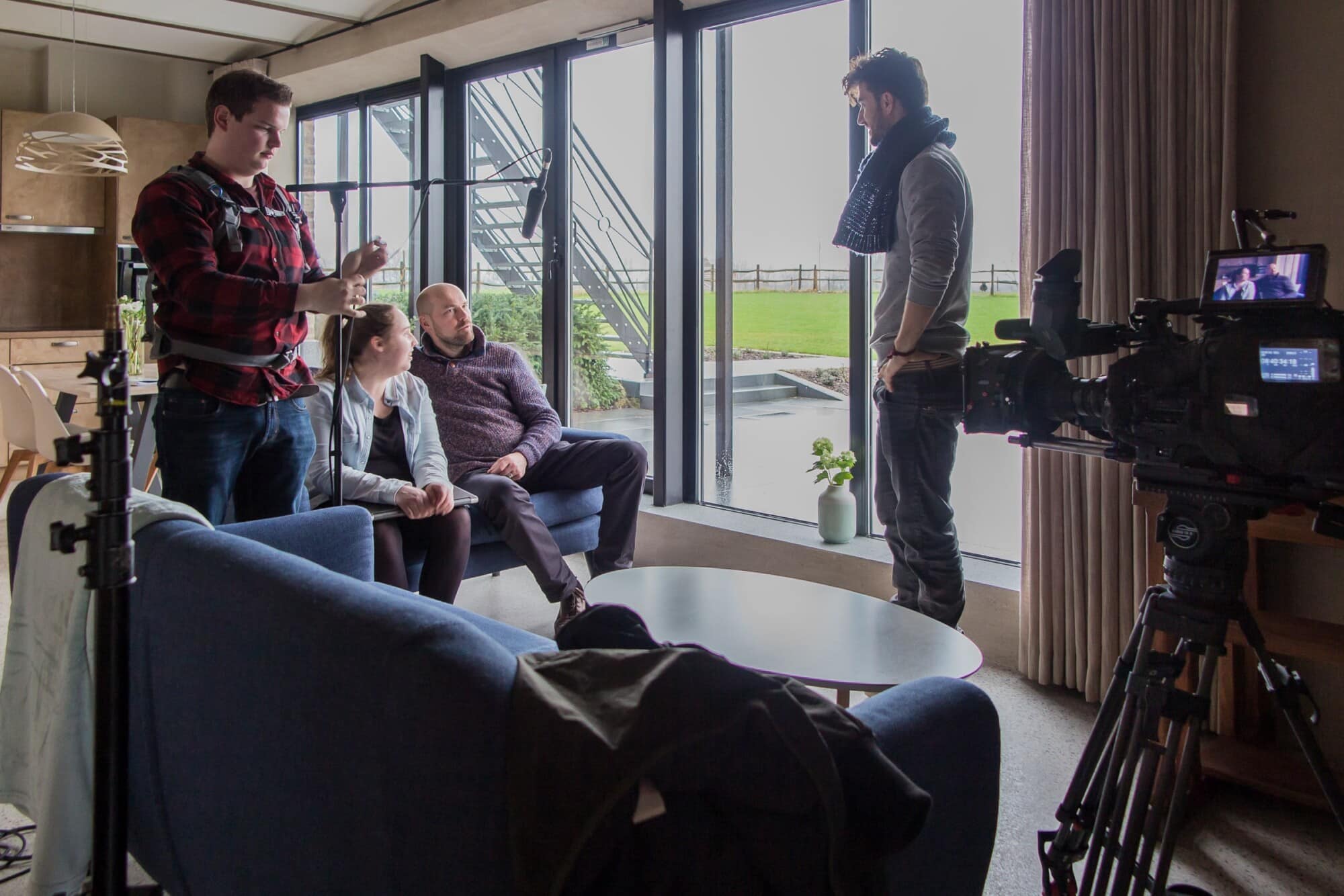 Interview opname bij Radio Star in moderne woonkamer met filmcrew en gasten voor Helemaal Herzele programma