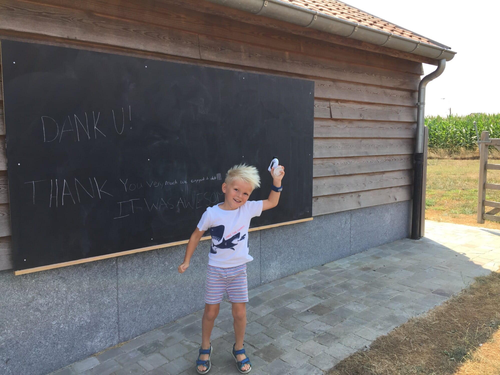 Blonde jongen schrijft dankbericht op krijtbord bij vakantiewoning Eyndevelde in Vlaamse Ardennen