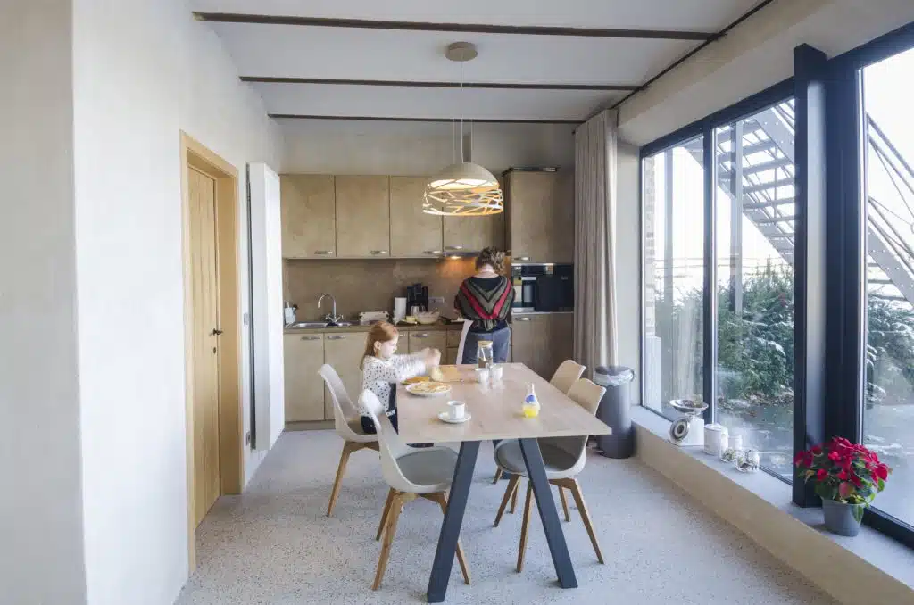 Modern keuken en eetkamer in Eyndevelde vakantiewoning met houten balken en grote ramen