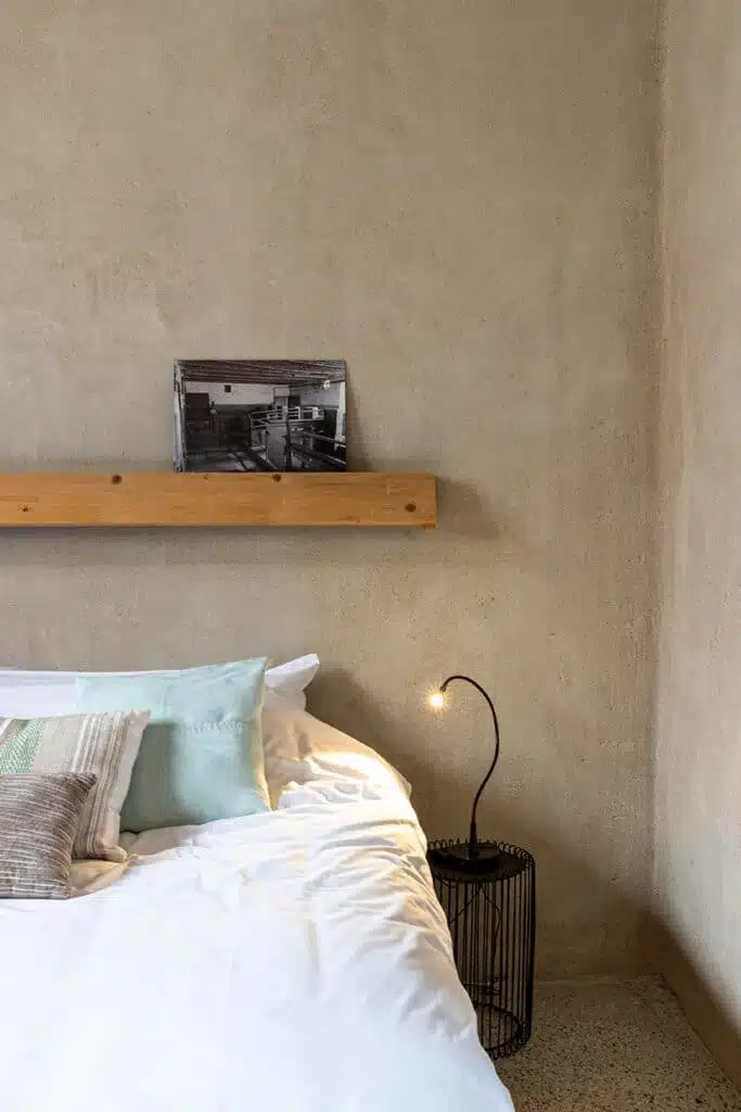 Gezellige slaapkamer in Eyndevelde vakantiewoning met comfortabel bed, mint kussens en moderne wandlamp