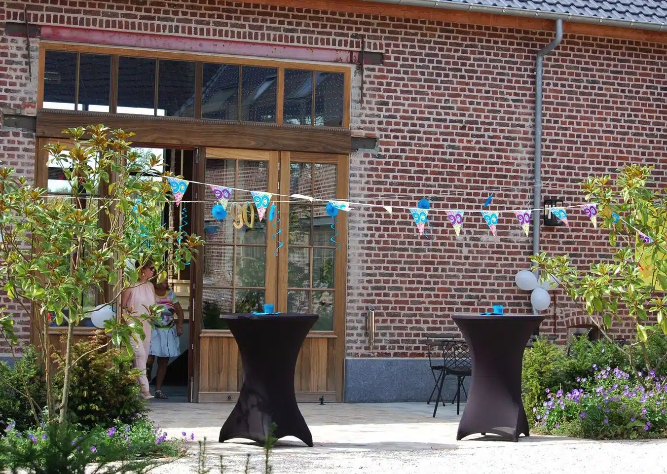 Terras van Eyndevelde vakantiewoning met statafelstelling, ballonnen en feestversiering voor groepsevents