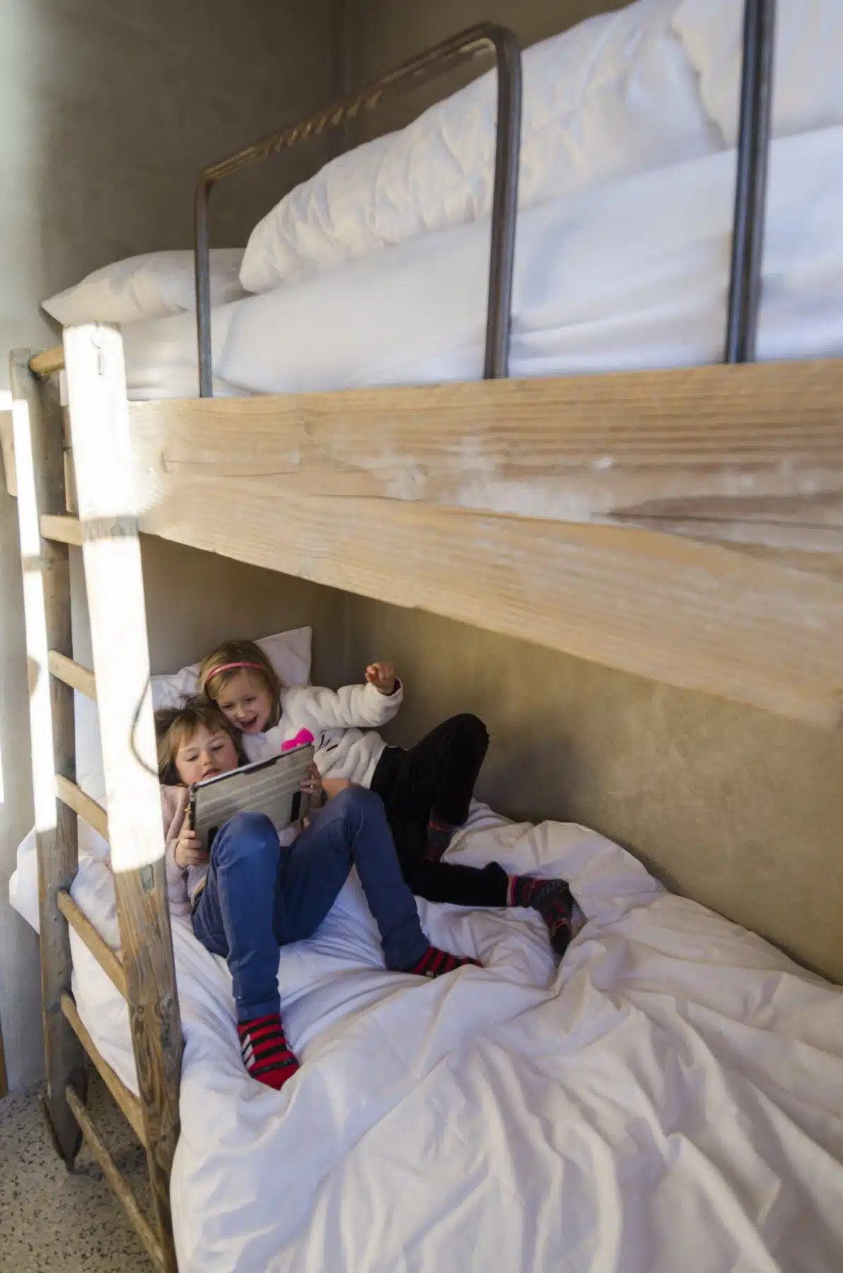 Twee kinderen lezen samen een boek op de onderste stapelbed in een gezellige slaapkamer