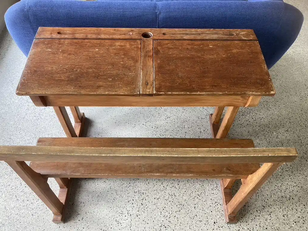 Vintage houten schoolbank met inktwel en bijpassende houten bank, tentoongesteld bij Eyndevelde